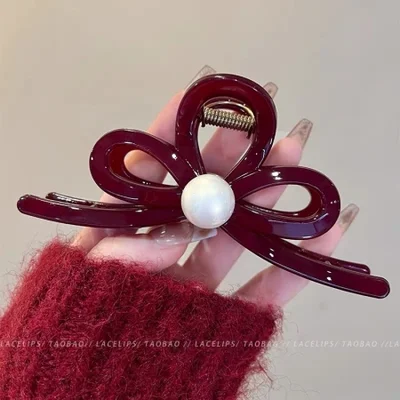 يعد مشبك المخلب الكبير ذو اللون الأحمر المخملي العصري لعام 2024 أمرًا ضروريًا للعام الجديد، حيث يتميز بمشبك شعر على شكل سمكة قرش في الجزء الخلفي من الرأس